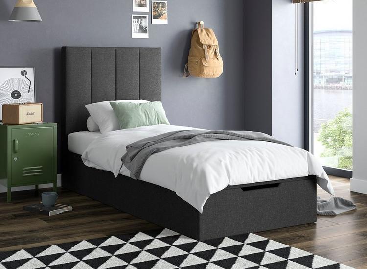 A teen room, styled with dark grey walls and a single grey ottoman storage bed.